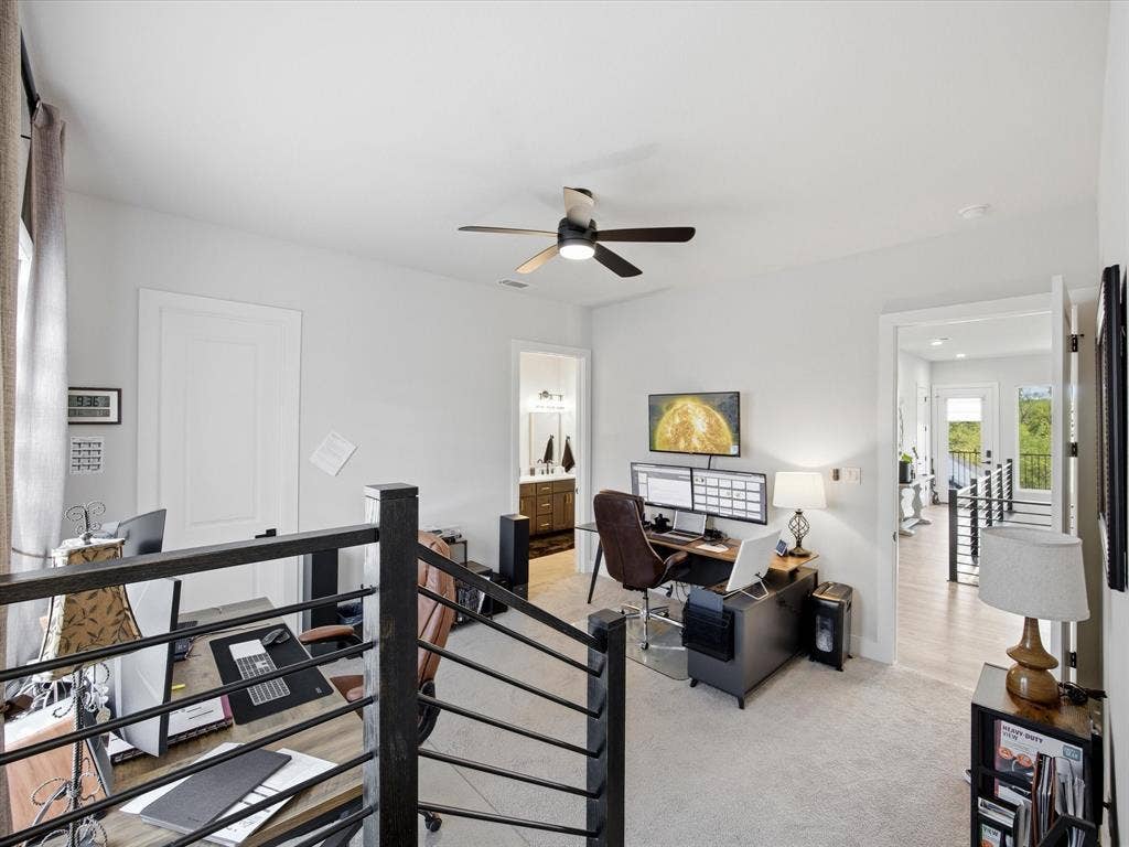 Office space featuring a ceiling fan and light colored carpet