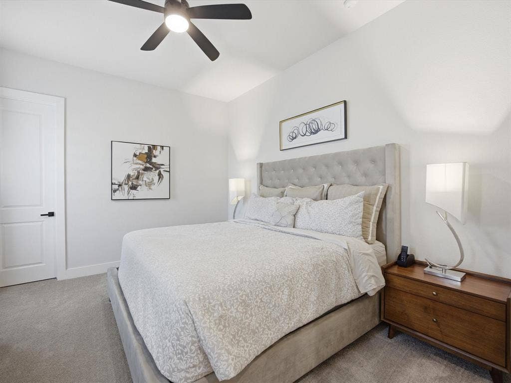 Bedroom with light colored carpet and a ceiling fan