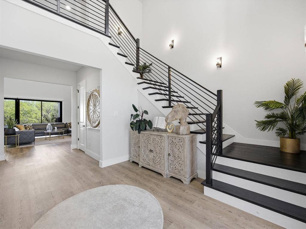 Stairway with a high ceiling and wood finished floors