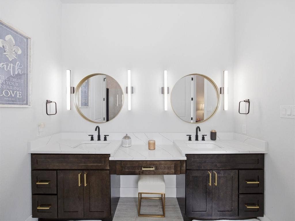 Full bathroom featuring double vanity and baseboards