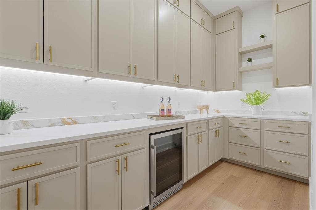 3424 Navaro Street, Dallas, TX 75212 Contemporary kitchen featuring cream-painted cabinetry with brushed gold hardware, white quartz countertops, and a full-height white subway tile backsplash