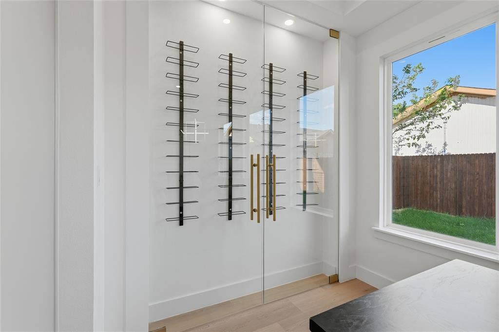 3424 Navaro Street, Dallas, TX 75212 Glass-enclosed storage with black metal shelving, brass-finish hardware, and recessed overhead lighting