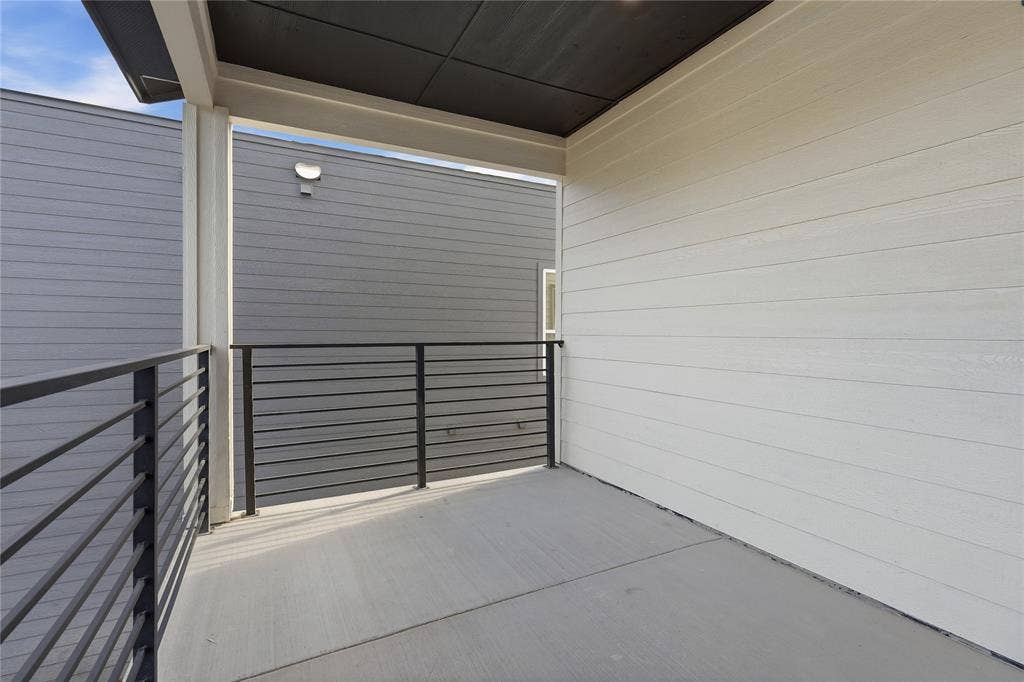 3424 Navaro Street, Dallas, TX 75212 Covered balcony with concrete flooring, modern black horizontal railing, and light-toned siding