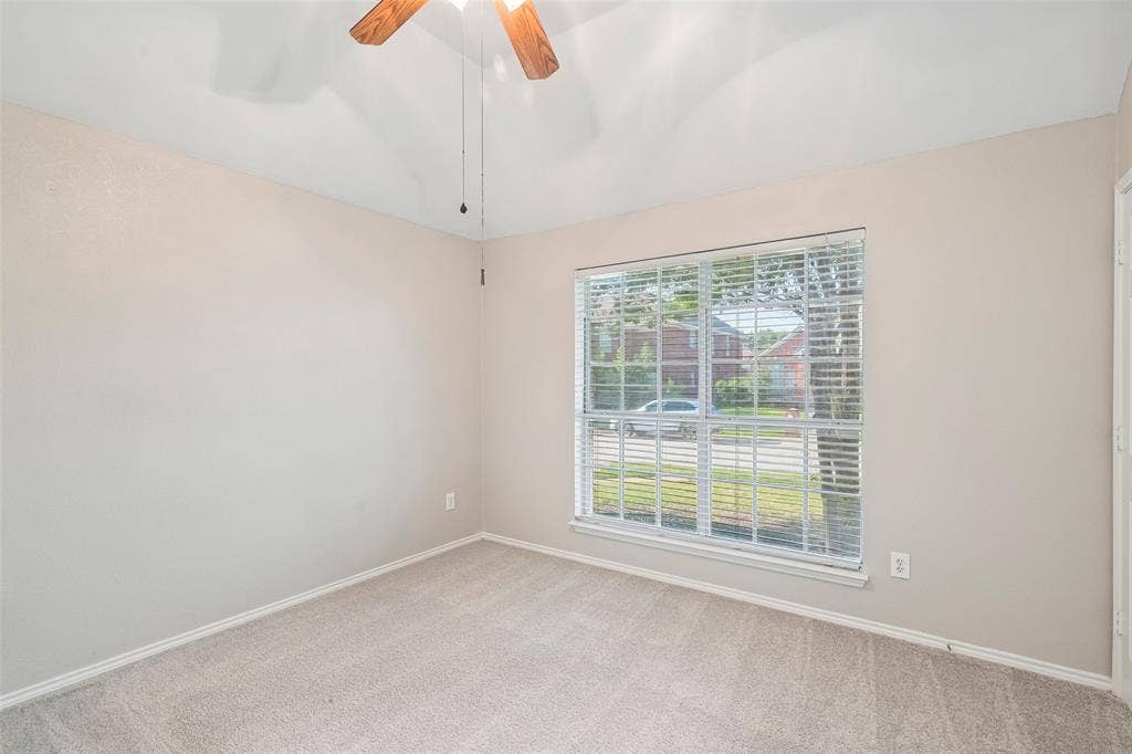 Carpeted flooring, window with blinds, ceiling fan with light fixture, and neutral wall paint