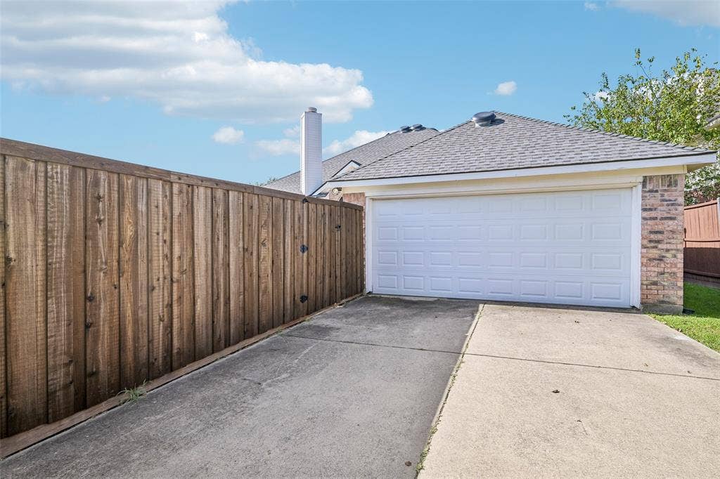 Attached garage with a panel door and brick siding- extra long driveway