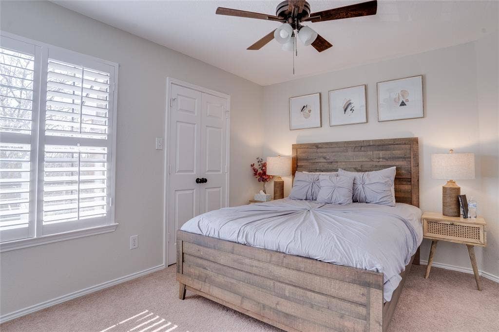 6003 Lloyd Court, Dallas, TX 75252 Hardwood ceiling fan with integrated lighting, window with plantation shutters, light-toned carpeting, and a double-door closet