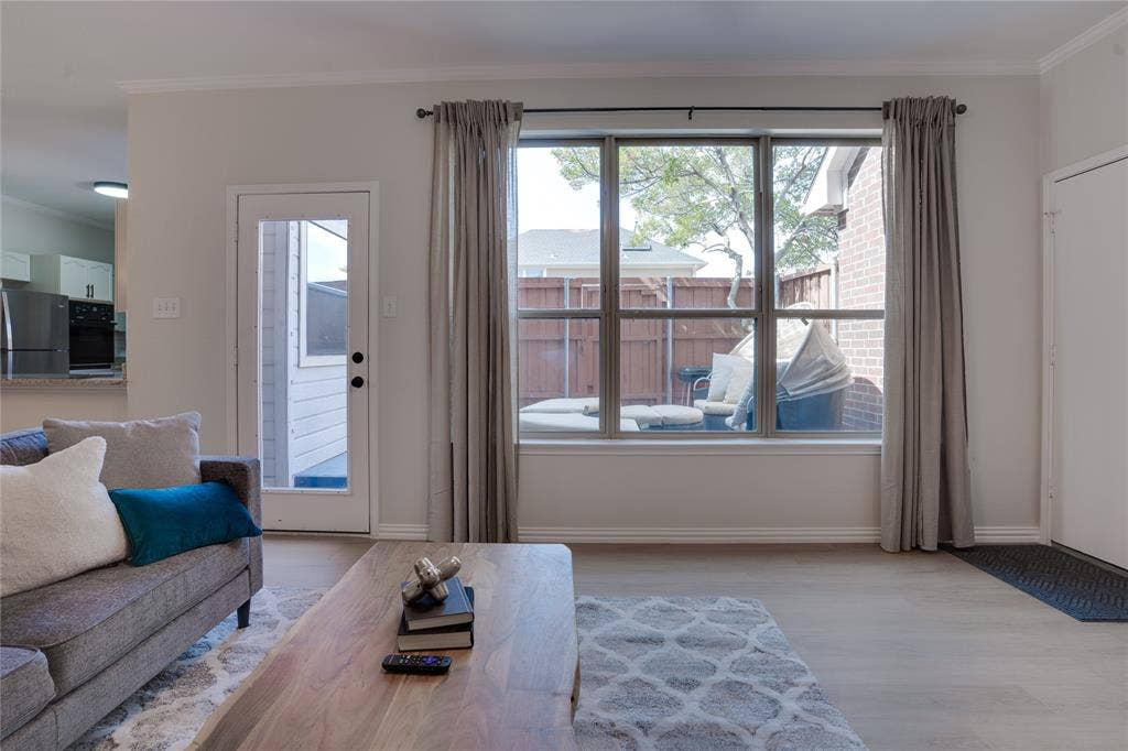 6003 Lloyd Court, Dallas, TX 75252 Light wood-finish flooring, a large multi-pane window, and a glass-paneled door provide ample natural illumination