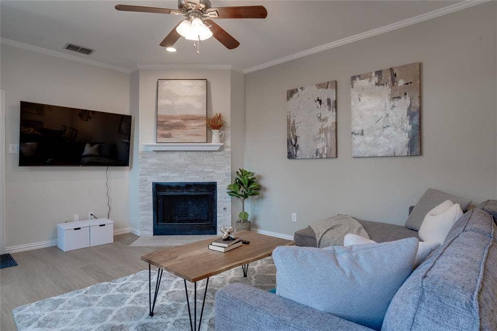 6003 Lloyd Court, Dallas, TX 75252 Living area with a corner fireplace featuring a stone surround and a mantel