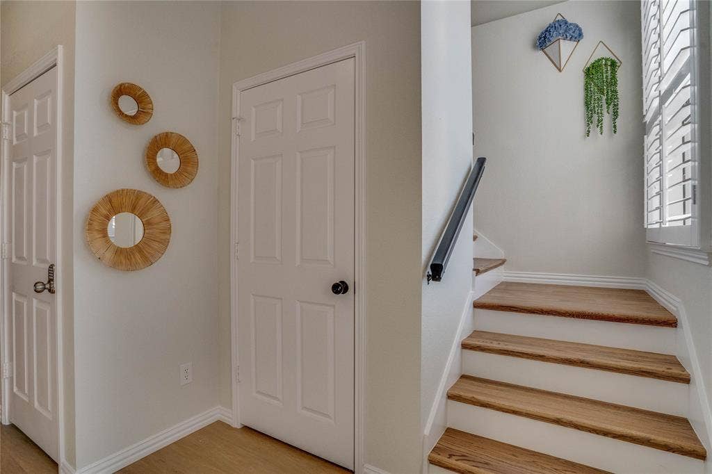 6003 Lloyd Court, Dallas, TX 75252 Hardwood treads, white risers, and a sleek black handrail define the staircase