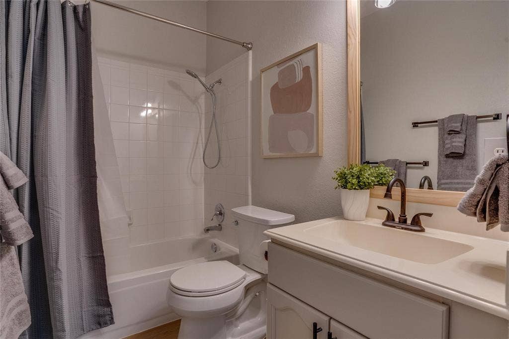 6003 Lloyd Court, Dallas, TX 75252 White tile shower surround over a tub with a chrome showerhead