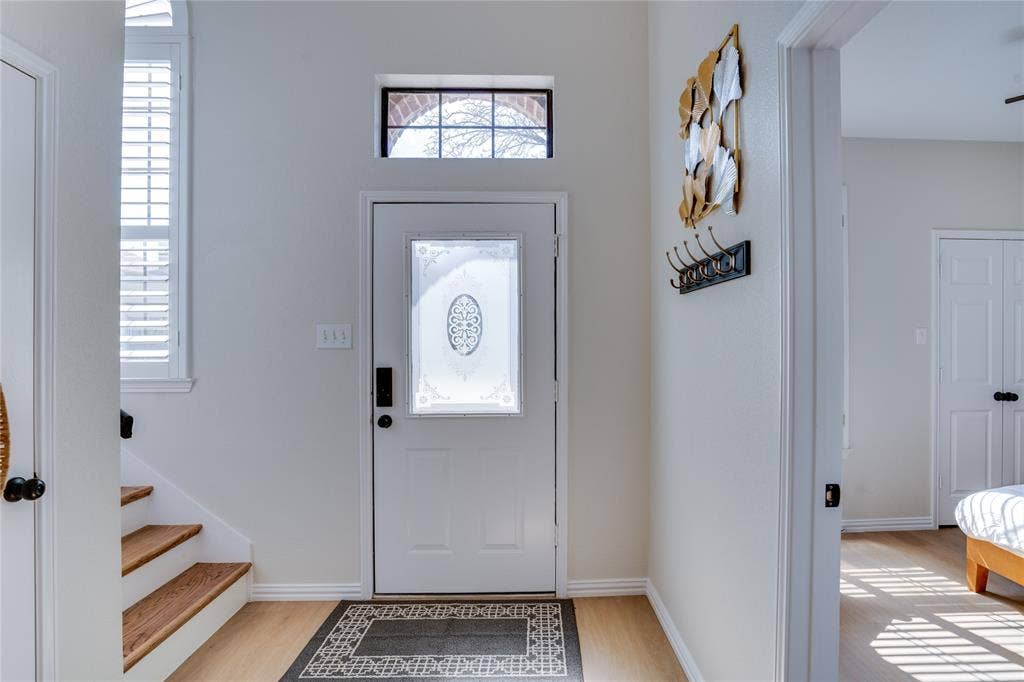 6003 Lloyd Court, Dallas, TX 75252 Entryway featuring a decorative frosted glass front door with transom window, wood-finish flooring, and natural light