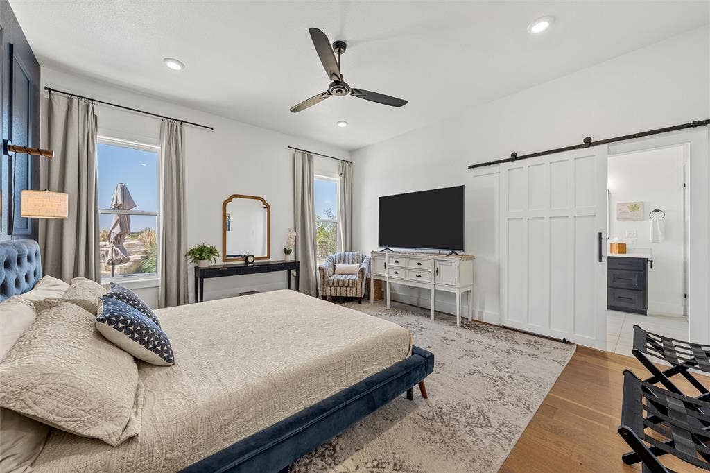 446 Wade Drive, Eddy, TX 76524 Recessed ceiling lighting, a modern ceiling fan, wood-finish flooring, and a white paneled barn door