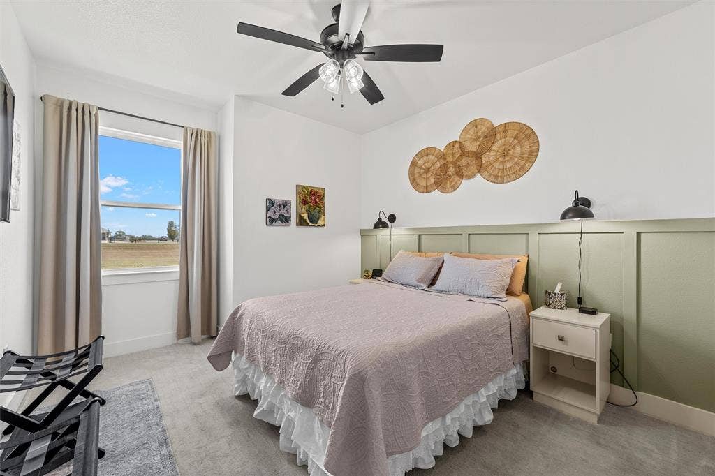 446 Wade Drive, Eddy, TX 76524 Recessed window with a spacious sill, board and batten accent wall, ceiling fan with integrated lighting, wall-mounted light fixtures, and plush carpet flooring