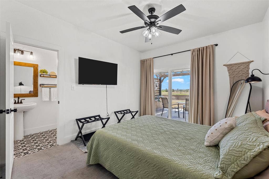 446 Wade Drive, Eddy, TX 76524 White walls featuring a ceiling fan, sliding glass door to exterior, and wall-mounted television