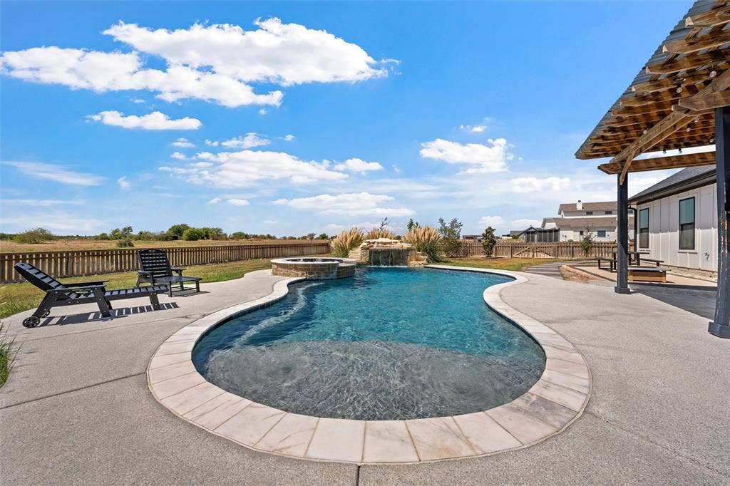 446 Wade Drive, Eddy, TX 76524 Curved swimming pool with integrated spa and waterfall feature