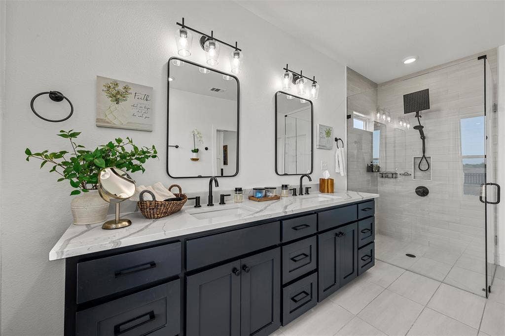 446 Wade Drive, Eddy, TX 76524 Dual vanity with stone-finish countertop, matte black fixtures, and framed mirrors