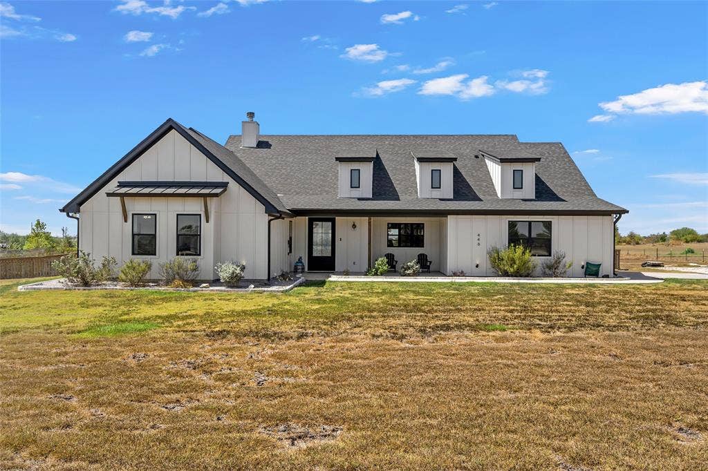 446 Wade Drive, Eddy, TX 76524 Modern farmhouse exterior featuring white vertical siding, black-framed windows, a dark shingled roof, a prominent front gable, and three dormer windows