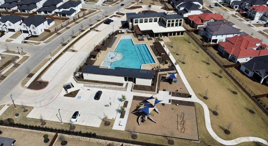 12512 Deer Trail, Frisco, TX 75035 Outdoor recreational area featuring a large swimming pool, a separate children's splash pad, and an extensive playground with shade structures