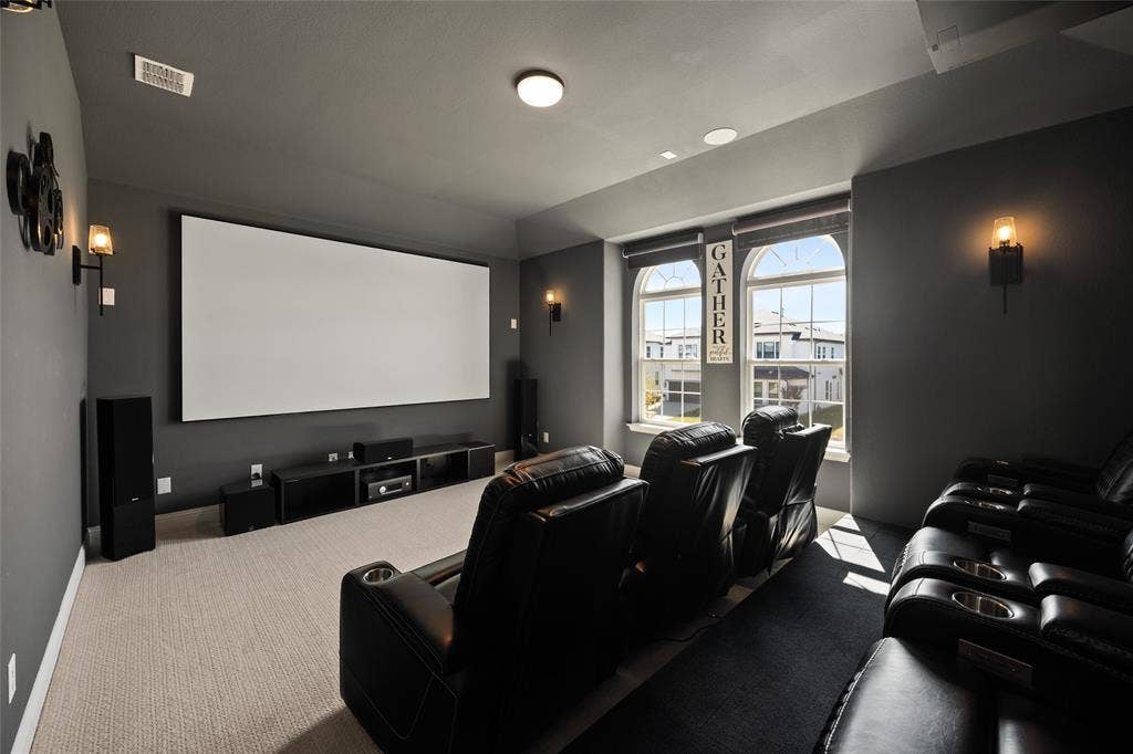 12512 Deer Trail, Frisco, TX 75035 Dedicated media room featuring a large projection screen, recessed lighting, wall-mounted sconces, and arched windows