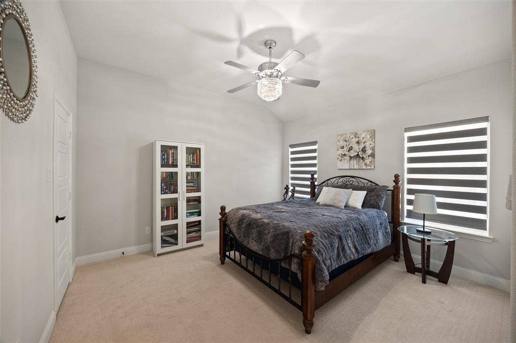 12512 Deer Trail, Frisco, TX 75035 Vaulted ceiling with a contemporary ceiling fan, two windows with horizontal banded shades, and carpet flooring