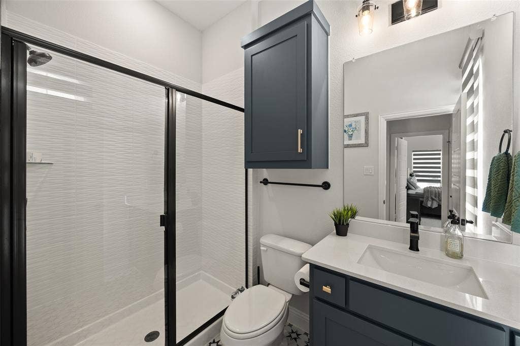 12512 Deer Trail, Frisco, TX 75035 Shower with black-framed glass enclosure and textured white wall tile