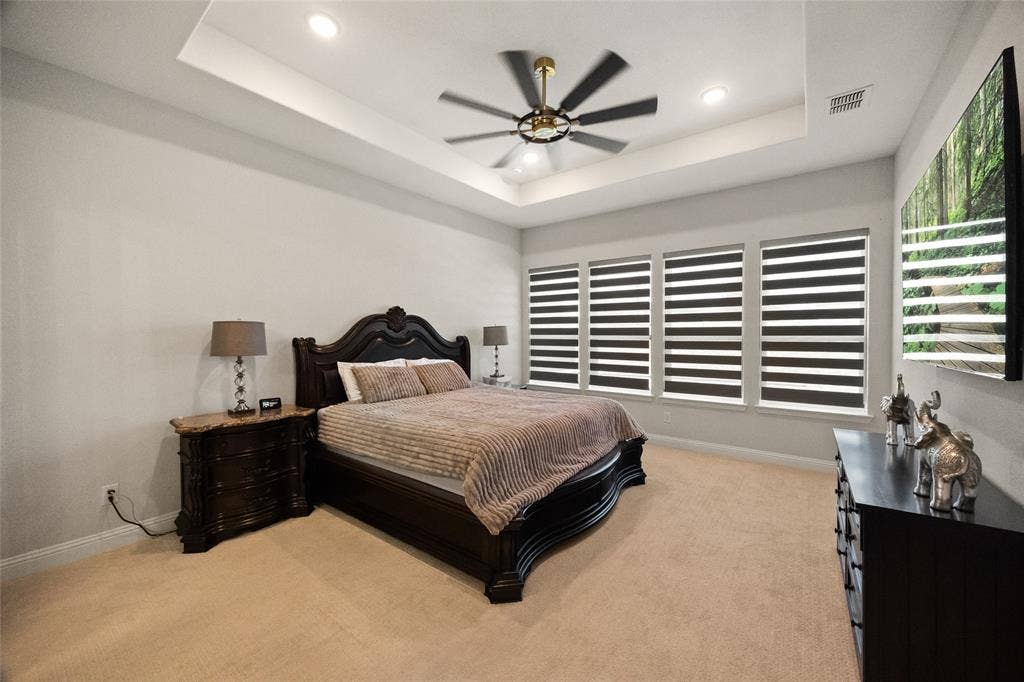 12512 Deer Trail, Frisco, TX 75035 Recessed lighting, tray ceiling, ceiling fan, carpet flooring, and multiple windows with blinds