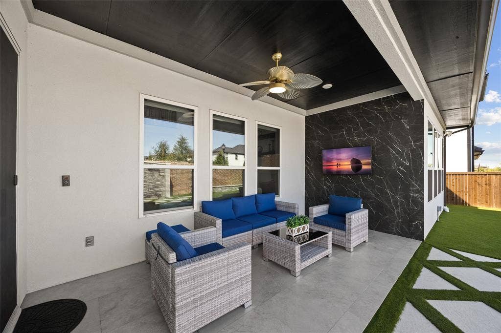 12512 Deer Trail, Frisco, TX 75035 Covered patio featuring a black ceiling with a ceiling fan, a black marble-effect accent wall, and a concrete paver floor