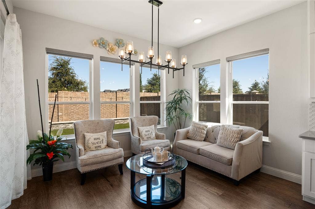 12512 Deer Trail, Frisco, TX 75035 Wood-finish flooring, a linear chandelier, recessed lighting, multiple windows, and light-colored walls