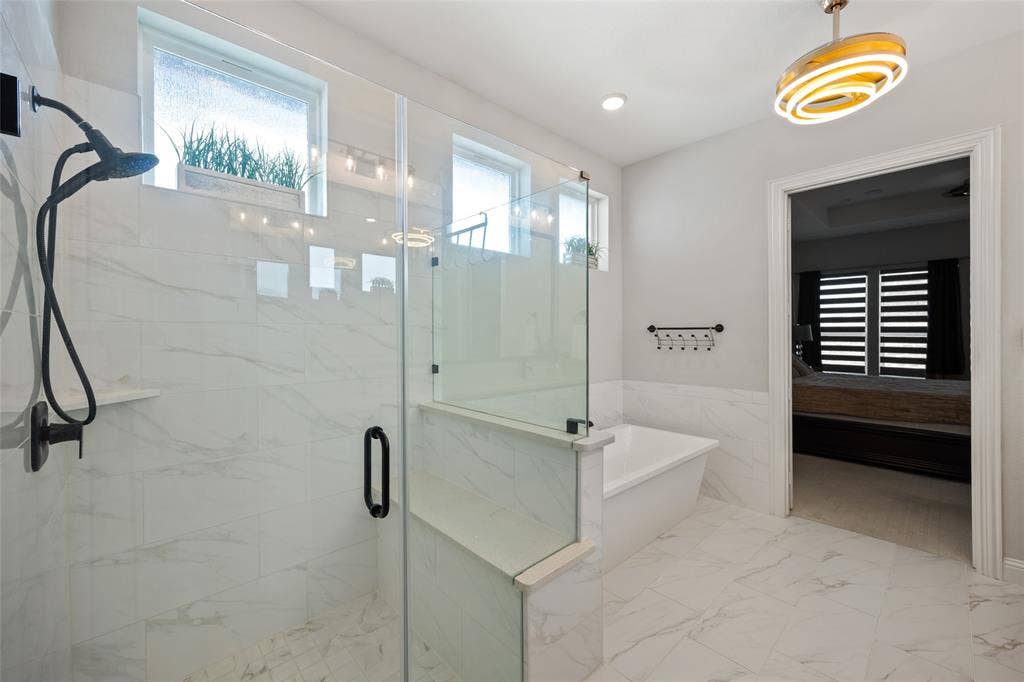 12512 Deer Trail, Frisco, TX 75035 Glass-enclosed shower with matte black fixtures, separate soaking tub, and large format tile flooring