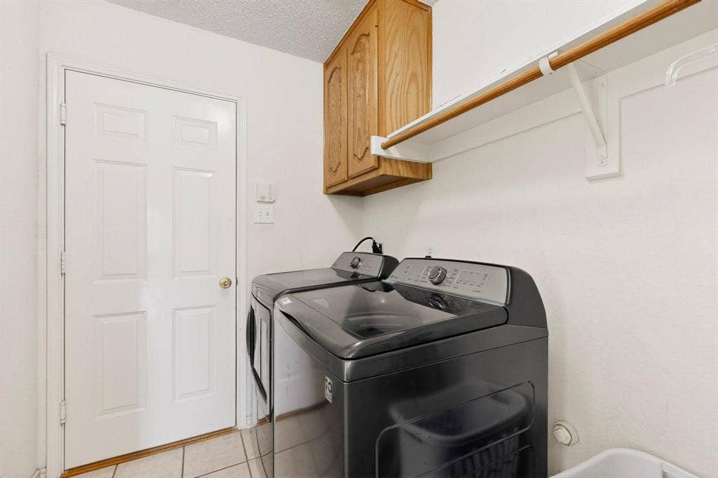 320 Elizabeth Trail, Murphy, TX 75094 White paneled door with brass hardware, tile flooring, and wood-finish cabinetry