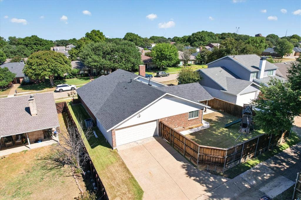 4448 Cleveland Drive, Plano, TX 75093 This rear aerial view highlights the home’s fenced backyard, covered patio and attached garage with alley access.