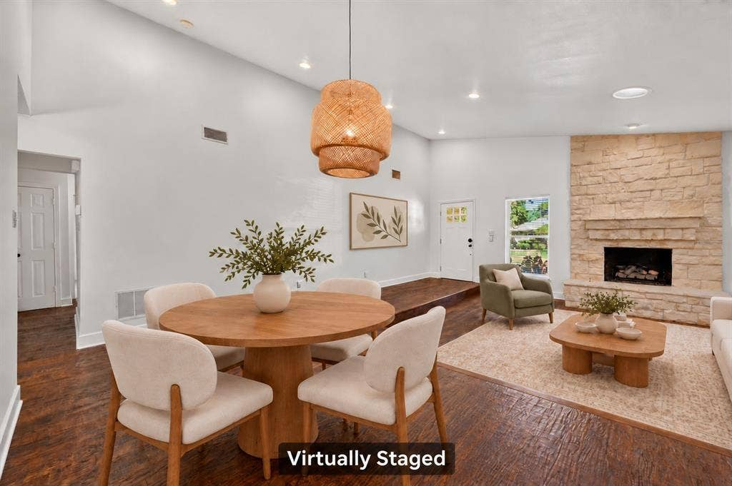 4448 Cleveland Drive, Plano, TX 75093 An inviting layout connects the dining and living areas, with a striking stone fireplace and nearby beverage storage space for easy entertaining. Virtually staged.