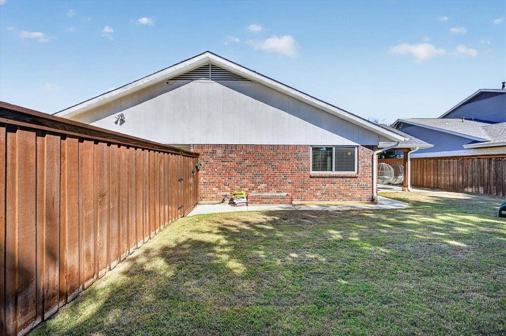 4448 Cleveland Drive, Plano, TX 75093 Enjoy a fenced backyard with grassy space, a brick planter box and a walkway leading to the covered patio.