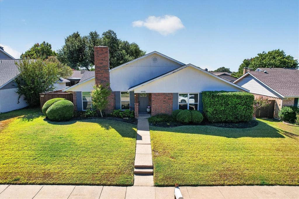 4448 Cleveland Drive, Plano, TX 75093 A welcoming front walkway, neatly shaped shrubs and a covered entry complement this home’s timeless brick exterior.