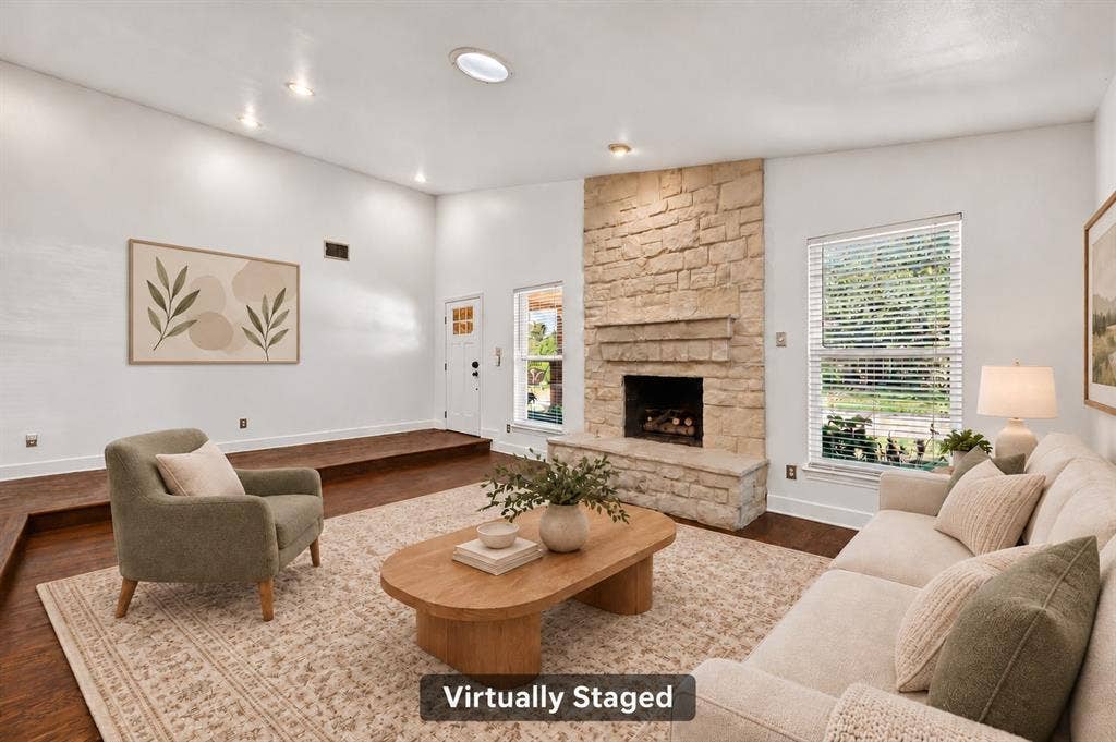 4448 Cleveland Drive, Plano, TX 75093 Gather in the comfortable step-down living room, featuring a floor-to-ceiling stone fireplace, gas logs and beautiful hand-scraped hardwoods. Virtually staged.