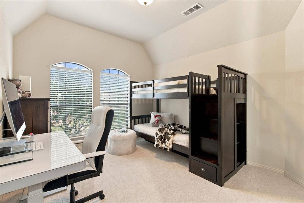 Vaulted ceiling, neutral wall tones, carpeted flooring, and dual arched windows