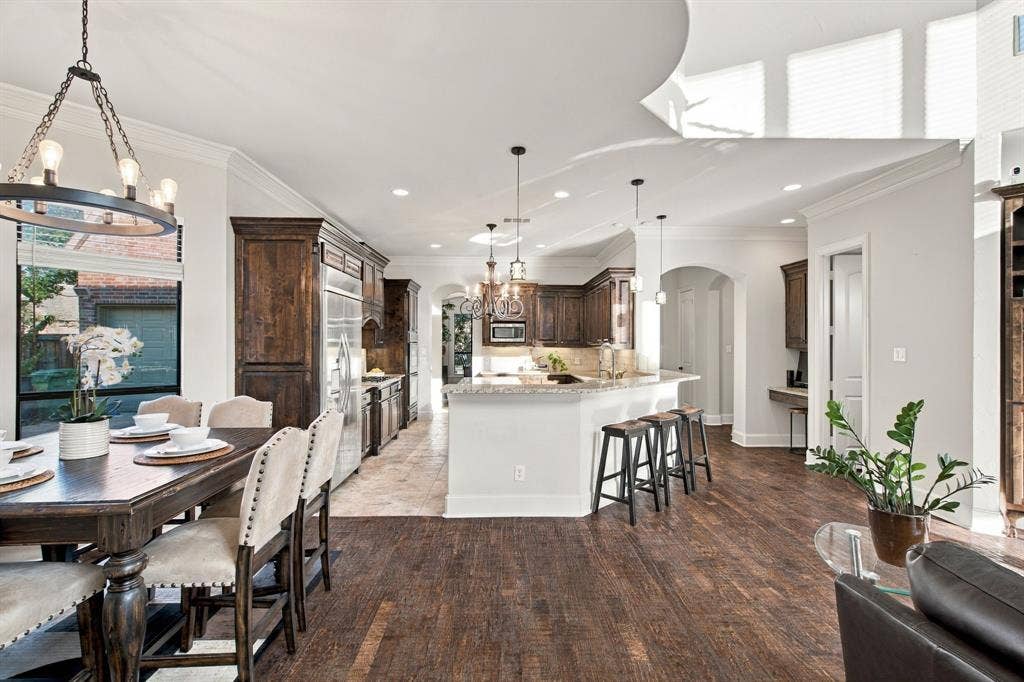 Kitchen featuring dark wood cabinetry, stone-surfaced breakfast bar, recessed lighting, tile flooring, and wood-finish flooring