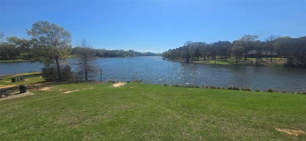 8300 Trophy Point, Larue, TX 75770 Expansive waterfront property featuring a wide lake frontage, surrounding mature trees, and a manicured lawn