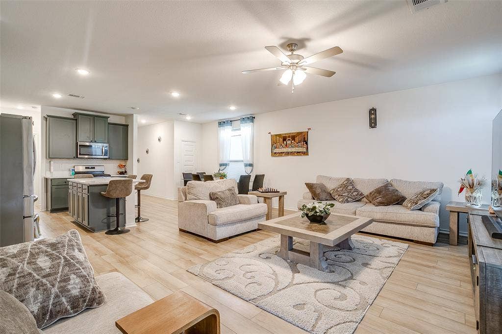Open-concept living space featuring wood-finish flooring, recessed lighting, and a ceiling fan