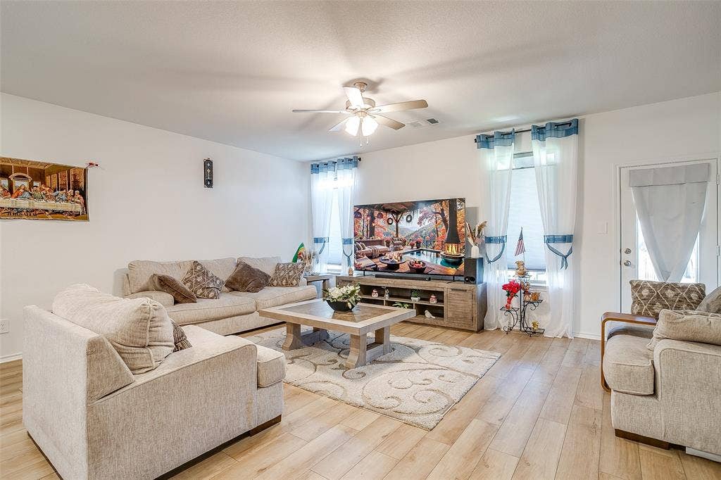 Recessed lighting, ceiling fan, wood-finish flooring, white walls, and a door with an exterior handle