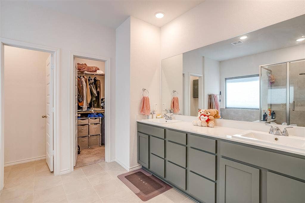 Dual vanity with white countertops, integrated sinks, and gray cabinetry