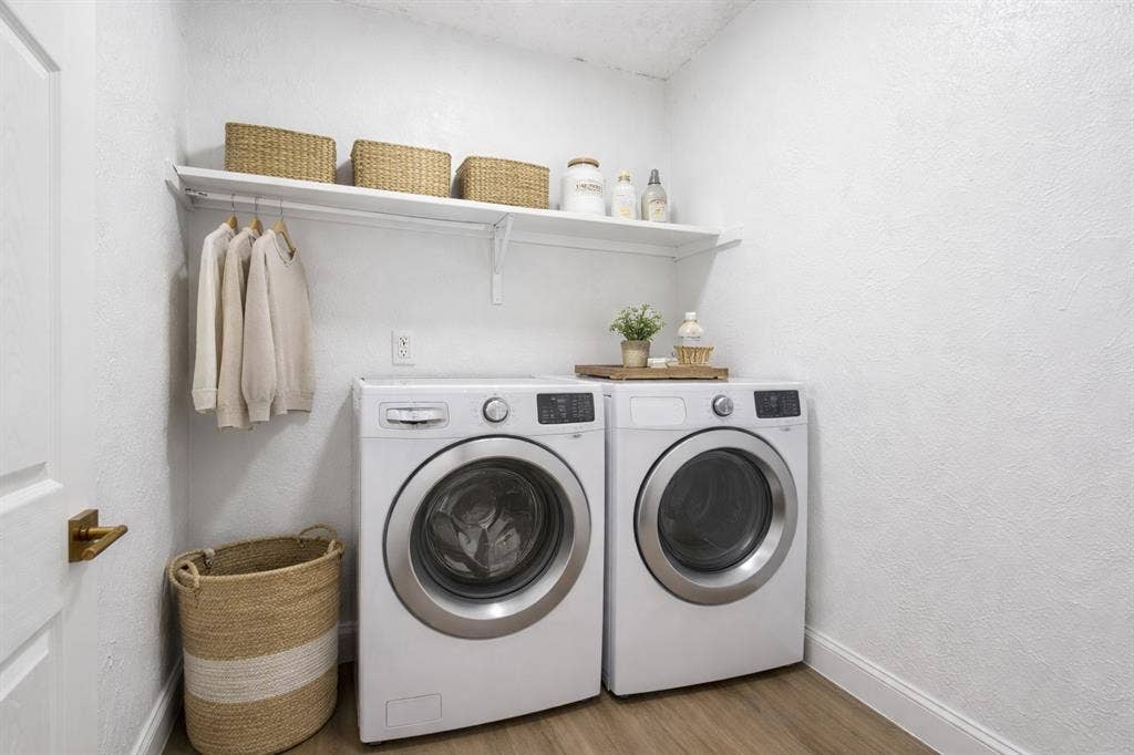 5514 Round Rock Road, Garland, TX 75044 Laundry area featuring wood-finish flooring and a wall-mounted shelf with a hanging rod