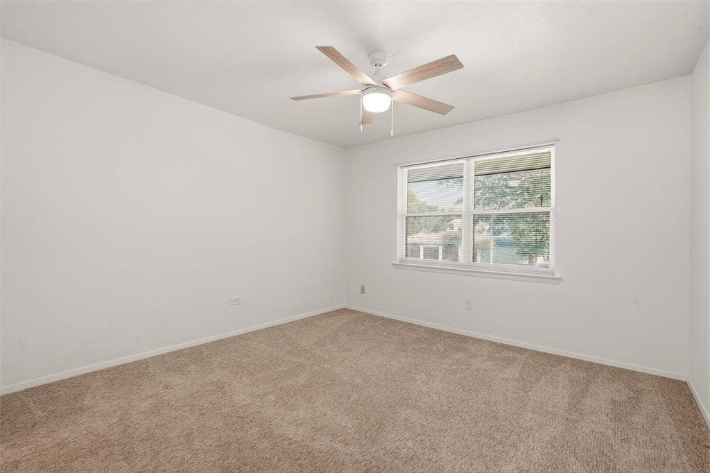 Bright corner bedroom with abundant natural light from dual windows, neutral wall finishes, and ceiling fan with integrated lighting