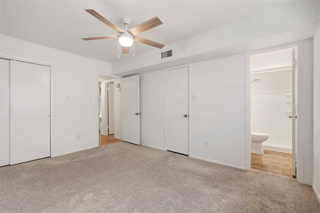 Wall-to-wall carpet flooring, ceiling fan with integrated lighting, and white bi-fold closet doors
