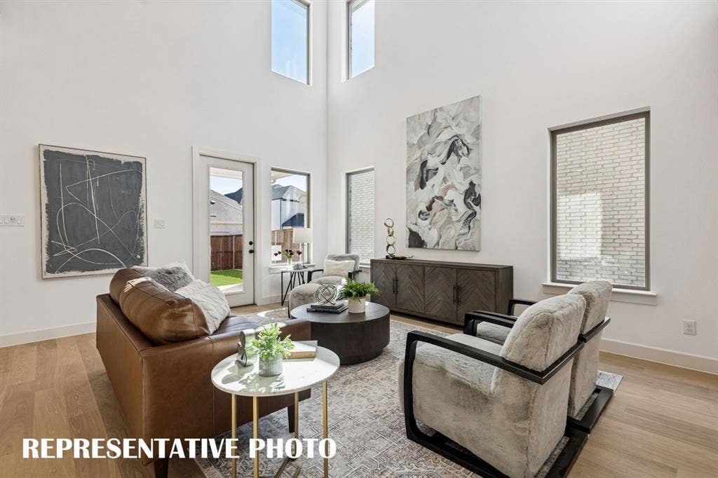 This spacious family room is flooded with natural light from oversized windows on the main and upper levels.REPRESENTATIVE PHOTO
