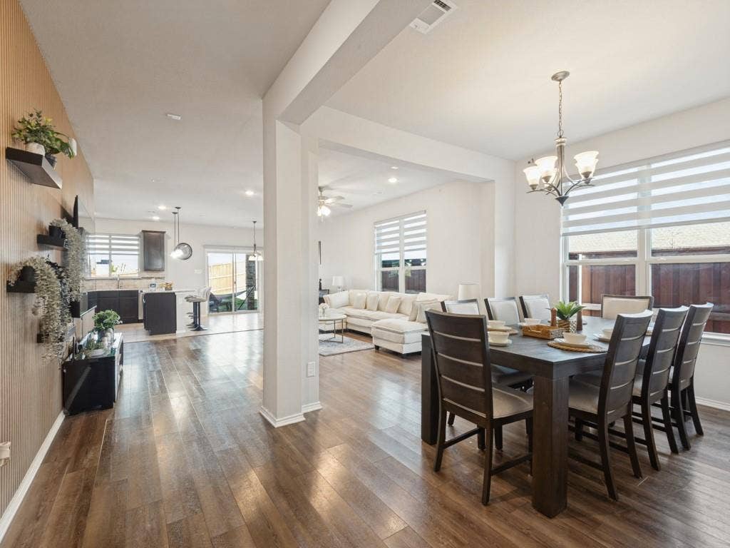 3825 S Courtney Court, Heartland, TX 75126 Wood-finish flooring throughout, bright interior spaces, recessed ceiling lighting, and a modern chandelier