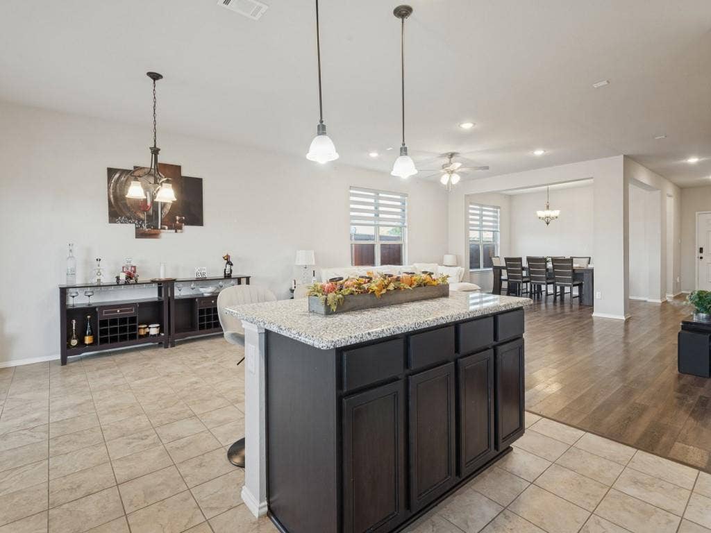 3825 S Courtney Court, Heartland, TX 75126 Kitchen island with dark cabinetry and a speckled countertop