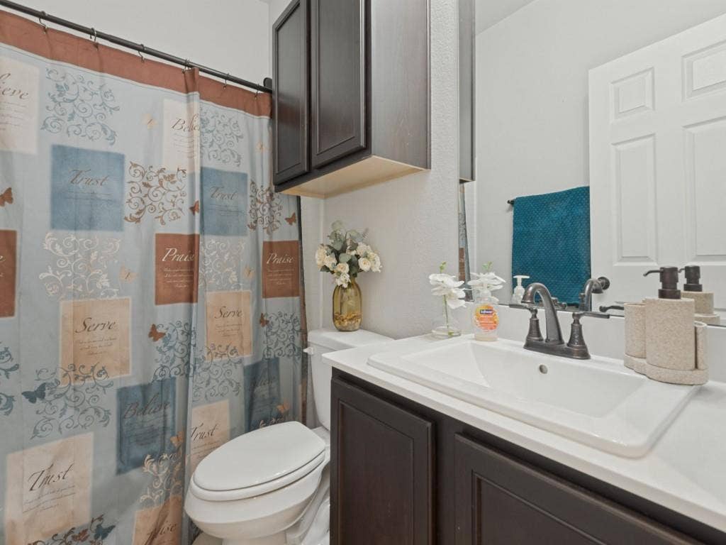 3825 S Courtney Court, Heartland, TX 75126 Recessed sink with dark wood-finish vanity, wall-mounted mirror, and cabinet storage
