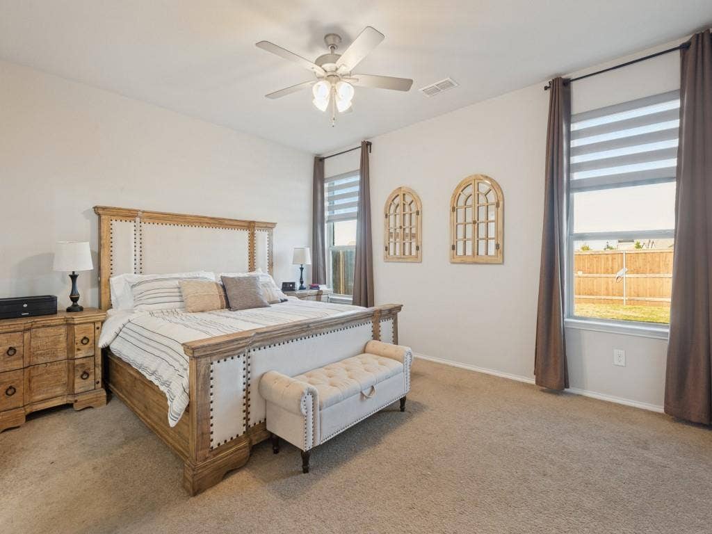 3825 S Courtney Court, Heartland, TX 75126 Carpeted flooring, ceiling fan with integrated lighting, two large windows, and a neutral color palette