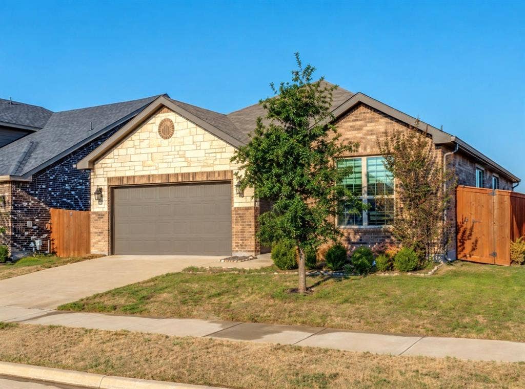 3825 S Courtney Court, Heartland, TX 75126 Brick and stone exterior with a gabled roofline and an attached garage